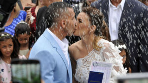 Argentine football star Carlos Tevez(L) and his wife Vanesa Mansilla, are seen during their marriage in San Isidro, Buenos Aires on December 22, 2016. Tevez and his now wife have lived together for the last 19 years and have three sons. / AFP PHOTO / NOTICIAS ARGENTINAS / Dario Batallan